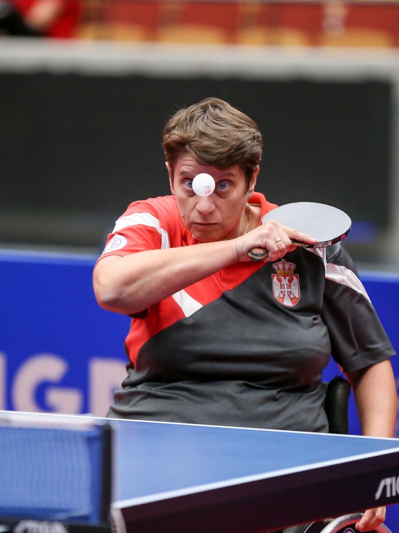Female table tennis player in wheelchair returns a shot